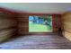 Inside outbuilding, natural wood walls and vinyl plank floors, with a large picture window overlooking the backyard at 7735 Westmoreland Dr, Sarasota, FL 34243