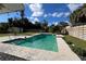 Backyard pool with stone surround, lush landscaping, and fenced in yard is perfect for enjoying a relaxing swim at 7735 Westmoreland Dr, Sarasota, FL 34243