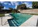 Backyard pool with steps, ladder, landscaped, a waterfall, and a new privacy fence at 7735 Westmoreland Dr, Sarasota, FL 34243
