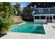 Backyard pool with blue tiled trim, privacy fence, and the exterior of the two-story home at 7735 Westmoreland Dr, Sarasota, FL 34243