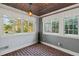 Cozy sunroom with brick flooring, wood ceiling and multiple windows for natural light and views at 7735 Westmoreland Dr, Sarasota, FL 34243