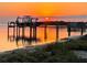 A picturesque sunset over a calm bay, with a boat lift, dock, and beautiful water views at 7735 Westmoreland Dr, Sarasota, FL 34243