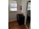 Narrow hall with wood floors features storage and a fire extinguisher near a window at 775 36Th S Ave, St Petersburg, FL 33705