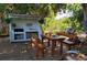 Outdoor kitchen and dining space, complete with lighting and lush backyard plants at 775 36Th S Ave, St Petersburg, FL 33705