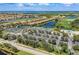 Aerial view showcasing tennis courts, community pool, lush green spaces, and several homes at 8205 Grand Estuary Trl # 102, Bradenton, FL 34212