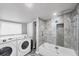 Bathroom with tiled shower, modern appliances, and convenient access to laundry facilities at 85 Cedar St, Englewood, FL 34223