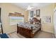 Bedroom features a wooden bed frame, window with blinds, ceiling fan and wood flooring at 9317 Saint Paul Drive, Port Charlotte, FL 33981
