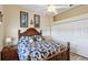 Cozy bedroom featuring a wooden bed frame, ceiling fan and white closet doors at 9317 Saint Paul Drive, Port Charlotte, FL 33981