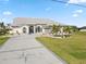 Beautiful home featuring a compass design driveway, arched windows, and manicured lawn with palm trees at 9317 Saint Paul Drive, Port Charlotte, FL 33981
