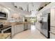 Open kitchen with stainless steel appliances, granite countertops, and breakfast bar at 9317 Saint Paul Drive, Port Charlotte, FL 33981