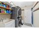 This laundry room has a stacked washer and dryer with shelving and a utility sink at 9317 Saint Paul Drive, Port Charlotte, FL 33981