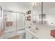 Bright bathroom with white cabinets, a shower over the tub and neutral tiling at 9393 Midnight Pass Rd # 506, Sarasota, FL 34242