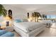 Bright bedroom with white furnishings, decorative lamps and access to lanai at 9393 Midnight Pass Rd # 506, Sarasota, FL 34242