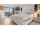 Bright bedroom with white furnishings, decorative lamps and access to lanai at 9393 Midnight Pass Rd # 506, Sarasota, FL 34242