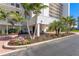 Exterior view of condo building with a circular drive, landscaping and covered entrance at 9393 Midnight Pass Rd # 506, Sarasota, FL 34242