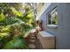 Exterior view showcases tropical foliage, including palm trees, alongside the home's textured siding and window at 965 N Boundry Road, Englewood, FL 34223