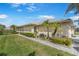 Lush backyard with tropical landscaping, paved walkway, and views of a serene pond in the distance at 9847 Hawk Nest Ln, North Port, FL 34287