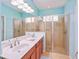 Bright bathroom features a double sink vanity and glass enclosed shower at 9847 Hawk Nest Ln, North Port, FL 34287