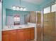 Bathroom with double vanity, walk-in shower, and neutral color scheme, adjoining the main bedroom at 9847 Hawk Nest Ln, North Port, FL 34287