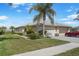 Well-maintained home exterior with lush landscaping, paver driveway, and attached two-car garage at 9847 Hawk Nest Ln, North Port, FL 34287