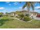 Exterior of property with a manicured lawn, lush landscaping, and a paver driveway leading to the garage at 9847 Hawk Nest Ln, North Port, FL 34287