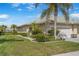 Charming home showcasing well-manicured landscaping, including lush green lawn and vibrant flower beds at 9847 Hawk Nest Ln, North Port, FL 34287
