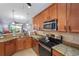 Well-equipped kitchen features stainless steel appliances and granite countertops, seamlessly integrates living spaces at 9847 Hawk Nest Ln, North Port, FL 34287