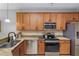 Modern kitchen with stainless steel appliances, granite countertops, and ample cabinet space for storage at 9847 Hawk Nest Ln, North Port, FL 34287