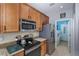 Efficient kitchen layout with stainless steel appliances leads to a bright laundry room, enhancing practicality at 9847 Hawk Nest Ln, North Port, FL 34287