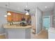 Well-lit kitchen with stainless steel appliances, granite countertops, and access to an adjacent bathroom at 9847 Hawk Nest Ln, North Port, FL 34287