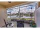 Relaxing screened-in lanai with peaceful lake view and rocking chairs for enjoying the outdoors at 9847 Hawk Nest Ln, North Port, FL 34287