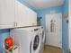 Functional laundry room with modern washer and dryer, offers convenience and ample storage solutions at 9847 Hawk Nest Ln, North Port, FL 34287