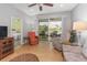 Inviting living room with tile floors, sliding glass doors to a lanai, and a view of the outdoors at 9847 Hawk Nest Ln, North Port, FL 34287