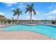 Sparkling community pool with lounge chairs and meticulously kept brick patio at 9847 Hawk Nest Ln, North Port, FL 34287