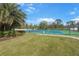 Outdoor tennis court with well-maintained green and blue surface, surrounded by lush landscaping and trees at 9847 Hawk Nest Ln, North Port, FL 34287