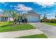 Charming single-story home with a paved driveway, lush landscaping, and a two-car garage under a blue sky at 995 Waterline Ct, Sarasota, FL 34240