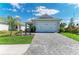 Charming single-story home with a paved driveway, lush landscaping, and a two-car garage under a blue sky at 995 Waterline Ct, Sarasota, FL 34240