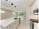 Modern kitchen with quartz island, stainless steel appliances, and sliding glass doors to the backyard at 995 Waterline Ct, Sarasota, FL 34240