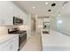Bright kitchen with stainless steel appliances, white cabinets, and a spacious quartz countertop island at 995 Waterline Ct, Sarasota, FL 34240