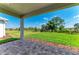 Covered patio looking out onto a green lawn with lush landscaping on a sunny day at 995 Waterline Ct, Sarasota, FL 34240