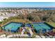 Aerial view of community tennis courts with lush landscaping and numerous houses in the background at 995 Waterline Ct, Sarasota, FL 34240