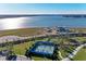 Aerial view of community tennis courts surrounded by lush landscaping and beautiful lake views at 995 Waterline Ct, Sarasota, FL 34240
