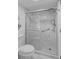 Close-up view of a glass enclosed shower with marble walls and tiled floor at 1001 Benjamin Franklin Dr # 510, Sarasota, FL 34236