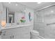 Bright bathroom featuring a marble vanity, toilet, and glass-enclosed shower at 1001 Benjamin Franklin Dr # 510, Sarasota, FL 34236