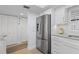 Modern kitchen featuring stainless steel refrigerator and white cabinetry at 1001 Benjamin Franklin Dr # 510, Sarasota, FL 34236