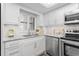 Well-lit kitchen with white cabinetry, granite countertops, and modern appliances at 1001 Benjamin Franklin Dr # 510, Sarasota, FL 34236