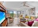 Bright living room with modern furnishings, TV, ceiling fan, and balcony access at 1001 Benjamin Franklin Dr # 510, Sarasota, FL 34236