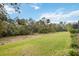 Spacious backyard with lush lawn and beautiful views of the surrounding greenery and mature trees at 10179 Milky Way Cir, Sarasota, FL 34241