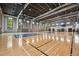 Indoor basketball court with pristine hardwood floors, professional hoops, and ample natural light at 10179 Milky Way Cir, Sarasota, FL 34241