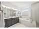 Luxurious bathroom with dual sinks, a soaking tub, a separate shower, and modern fixtures at 10179 Milky Way Cir, Sarasota, FL 34241